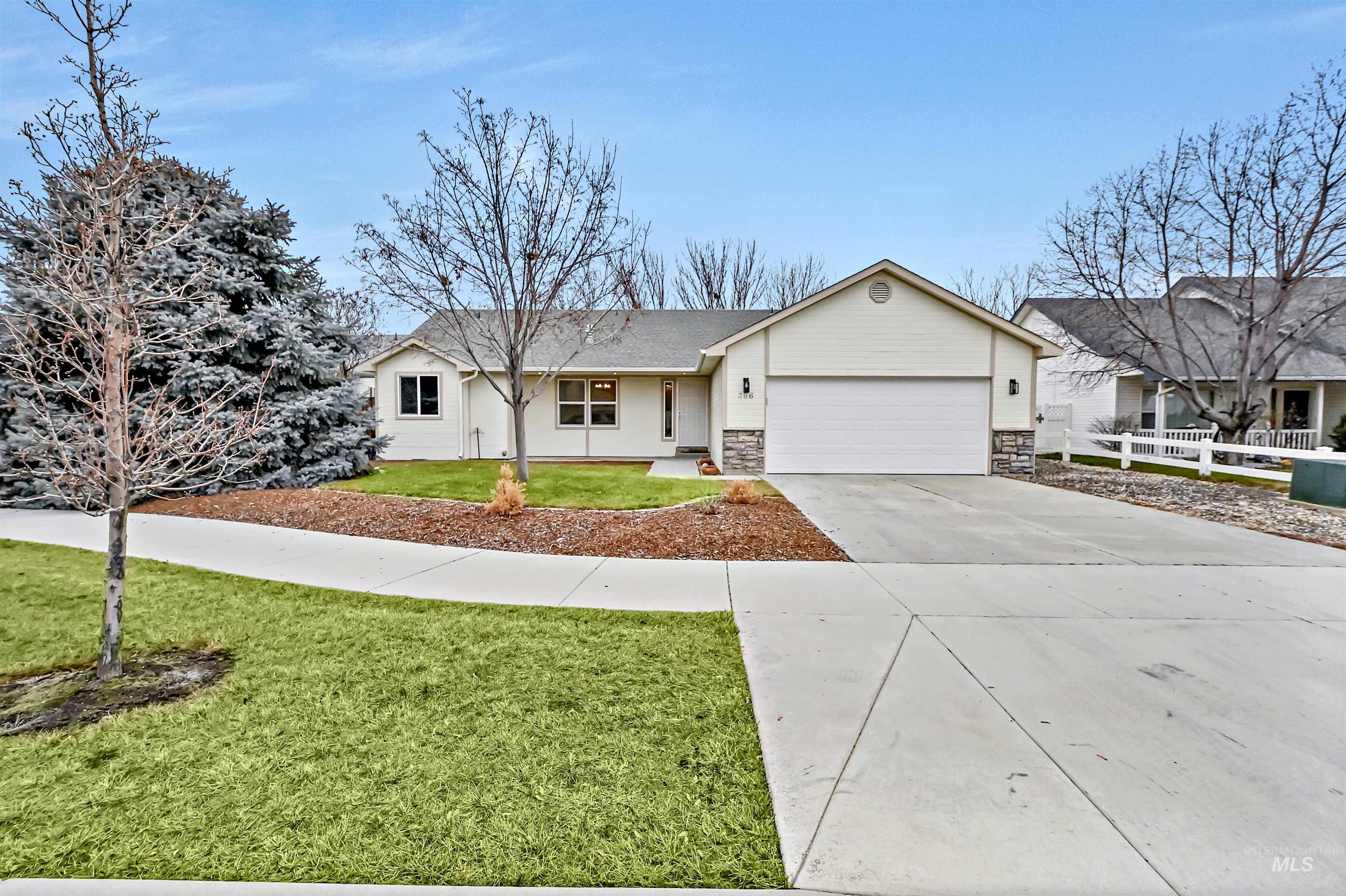 Ranch-style house with concrete driveway, an attached garage, stone siding, and a shingled roof
