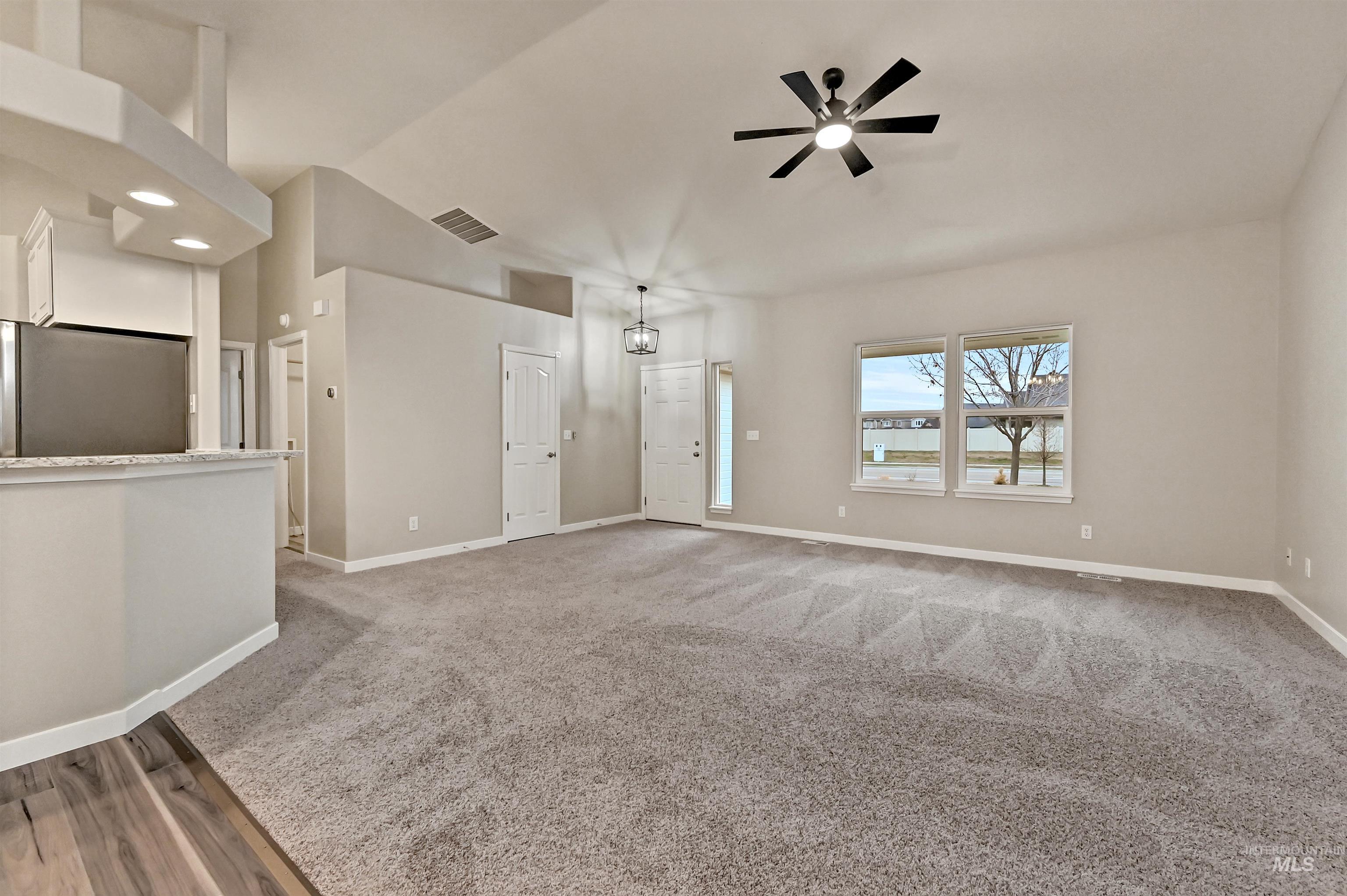 366 West Harris Street Meridian, ID 83642 - Photo 10 of 31 Unfurnished living room with lofted ceiling, light colored carpet, and ceiling fan