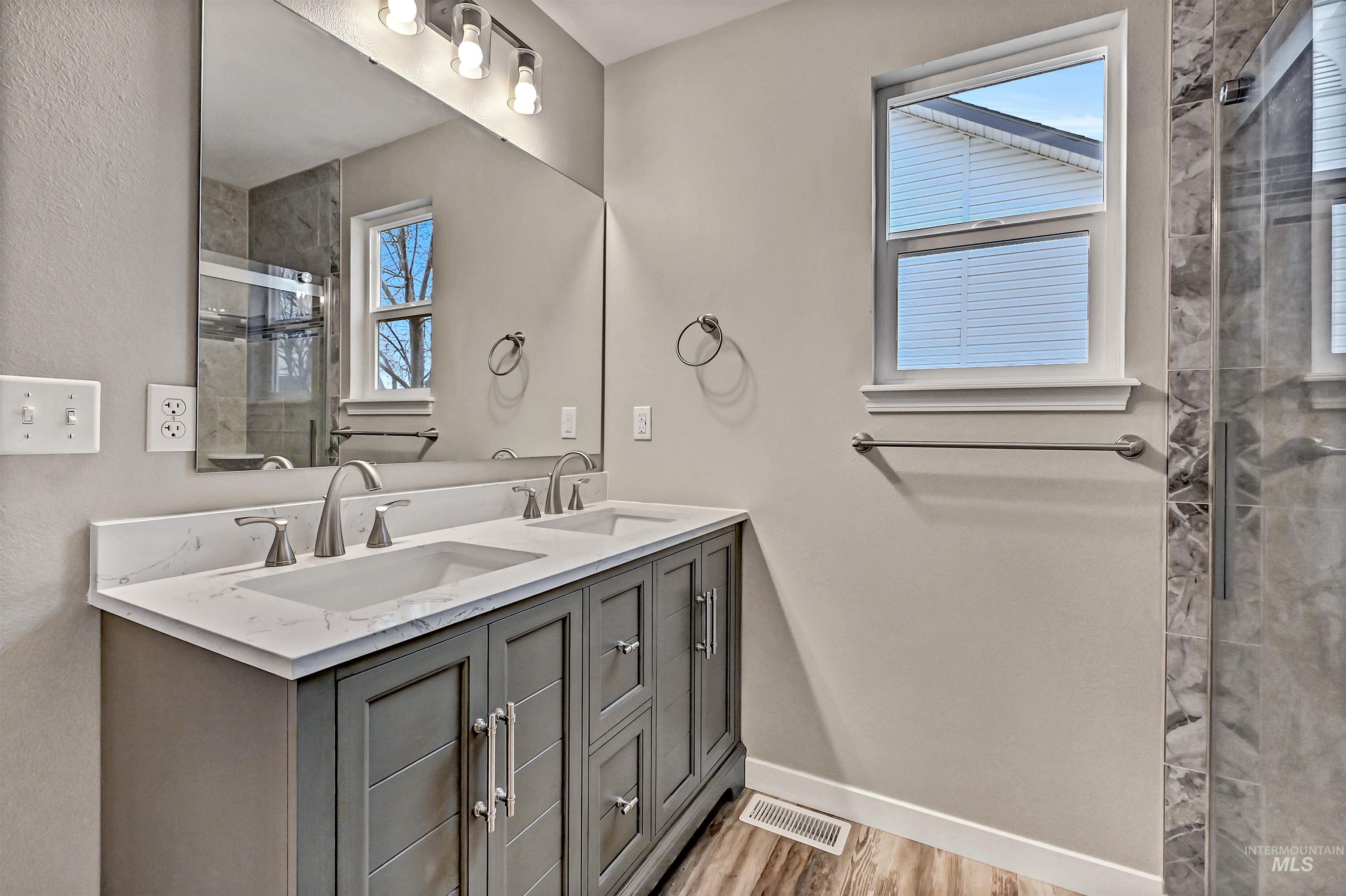 366 West Harris Street Meridian, ID 83642 - Photo 17 of 31 Full bath featuring double vanity, a stall shower, and light wood-type flooring