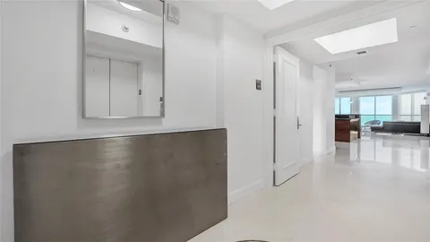 a view of a hallway with a dining table and chairs