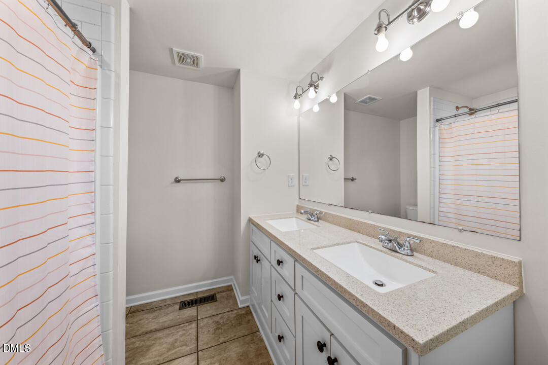 454 Cedar Creek Road Timberlake, NC 27583 - Photo 21 of 39 a bathroom with a sink a mirror and a shower