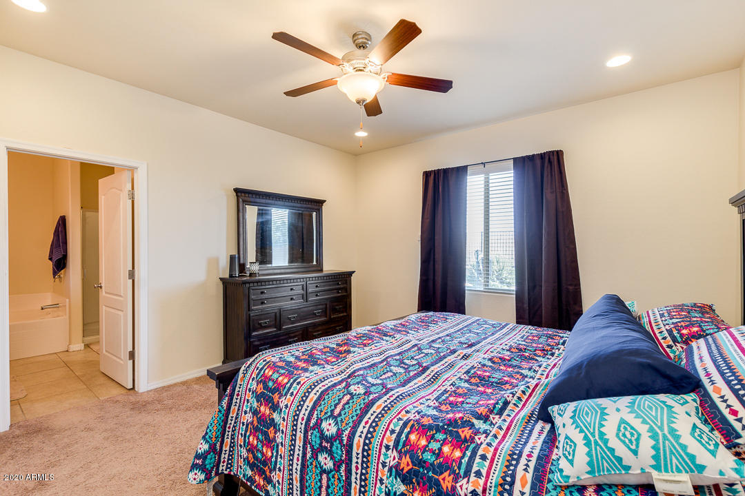 7615 West Carter Road Laveen, AZ 85339 - Photo 18 of 34 a bedroom with a bed and a chandelier