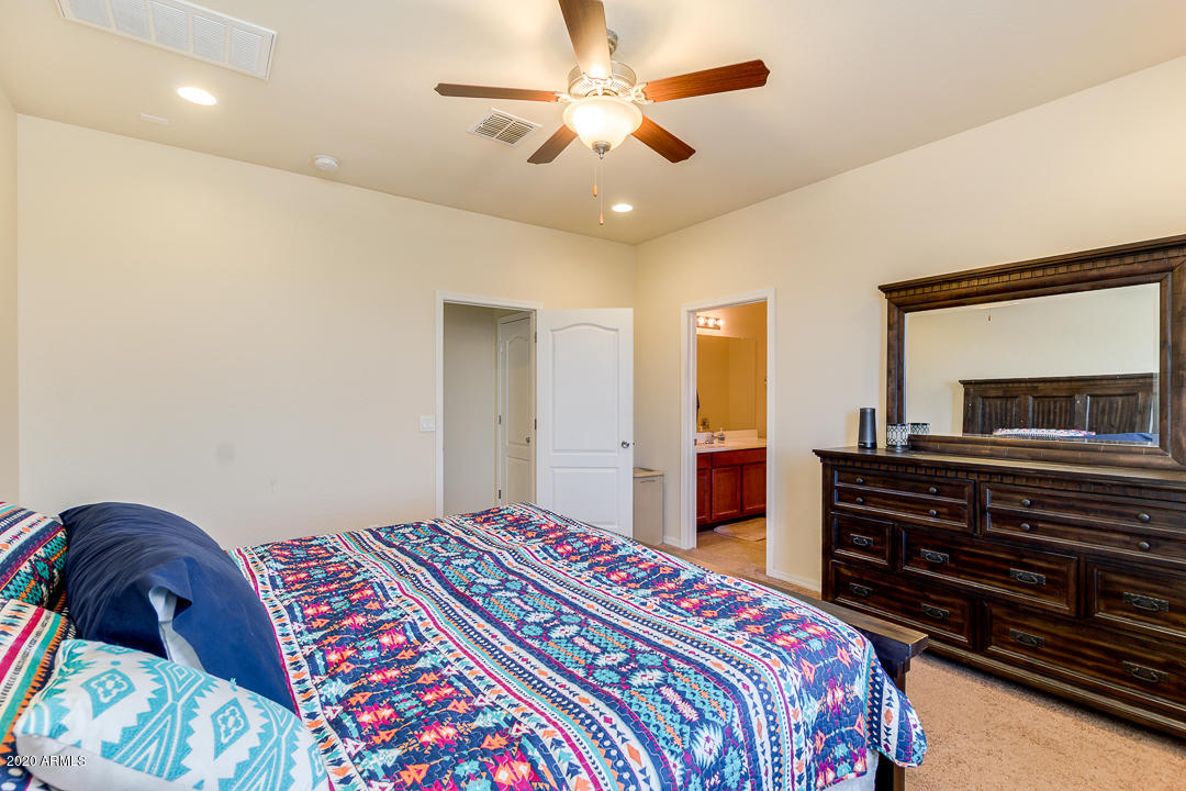 7615 West Carter Road Laveen, AZ 85339 - Photo 20 of 34 a bedroom with a bed and a dresser in it