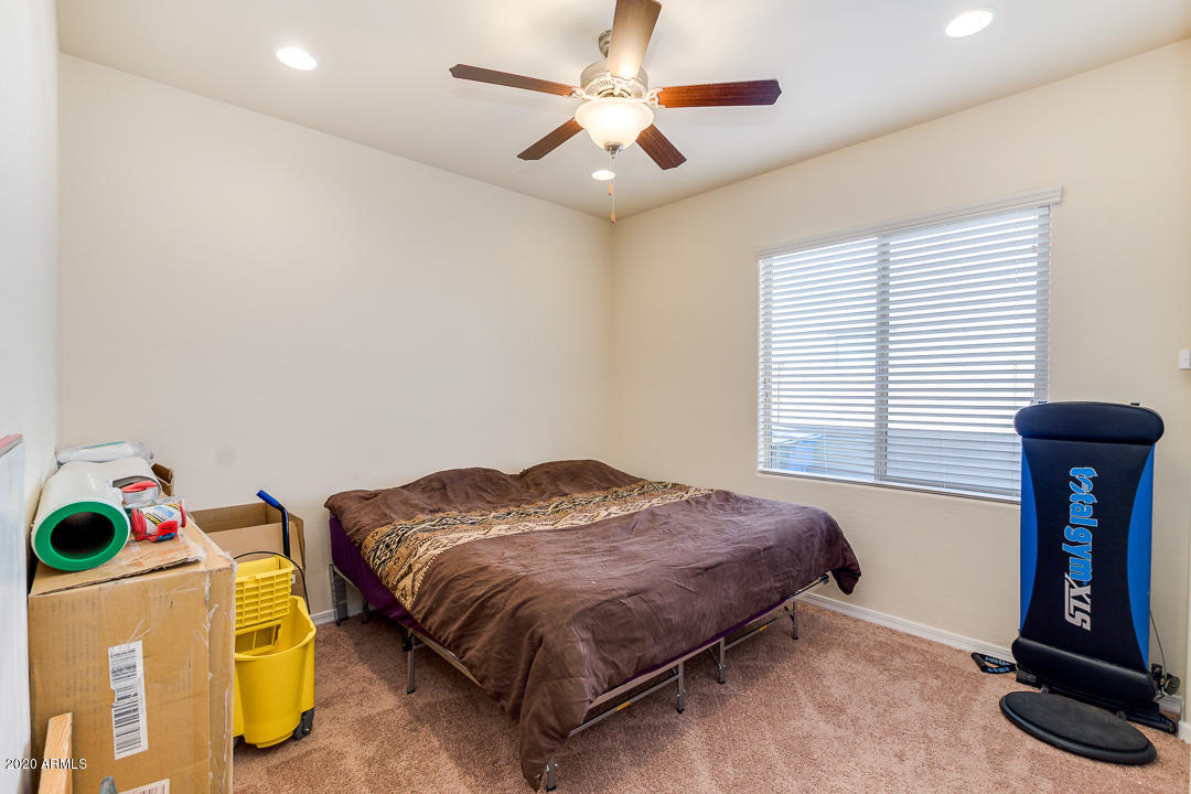 7615 West Carter Road Laveen, AZ 85339 - Photo 21 of 34 a bedroom with a bed and a chandelier