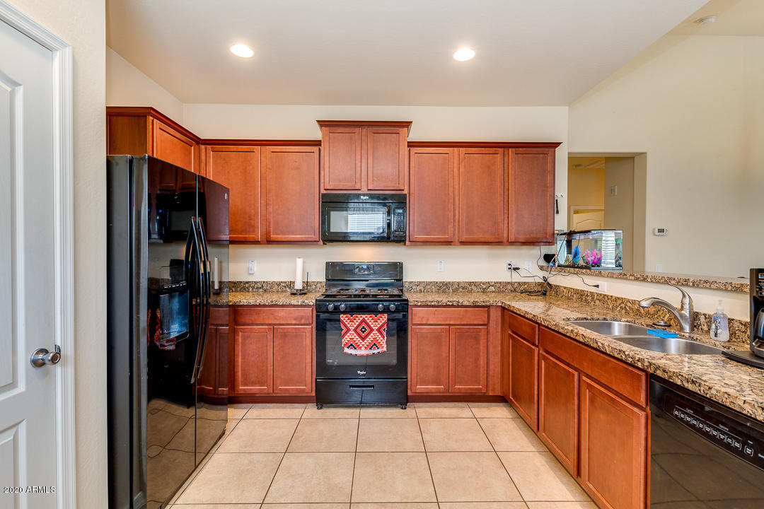 7615 West Carter Road Laveen, AZ 85339 - Photo 3 of 34 a kitchen with stainless steel appliances granite countertop a refrigerator and a stove top oven