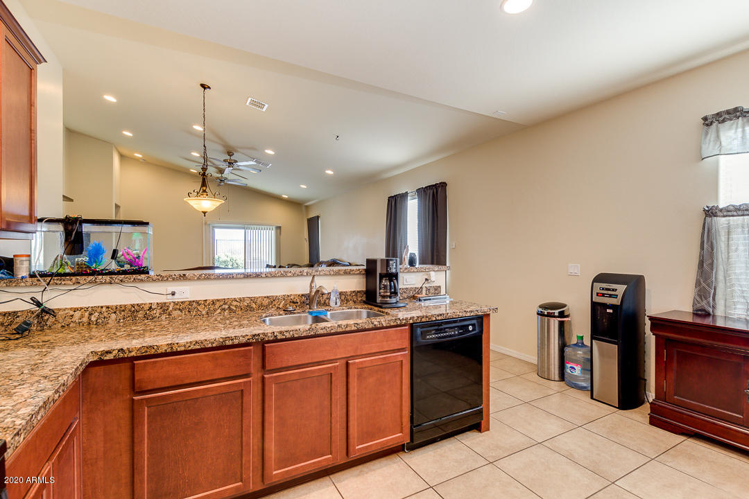 7615 West Carter Road Laveen, AZ 85339 - Photo 4 of 34 a kitchen with granite countertop a sink cabinets and stainless steel appliances
