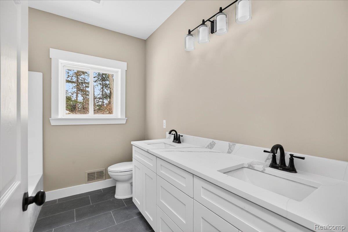 4050 Metamora Ridge Road Metamora, MI 48455 - Photo 50 of 65 Bathroom featuring double vanity and dark tile patterned floors