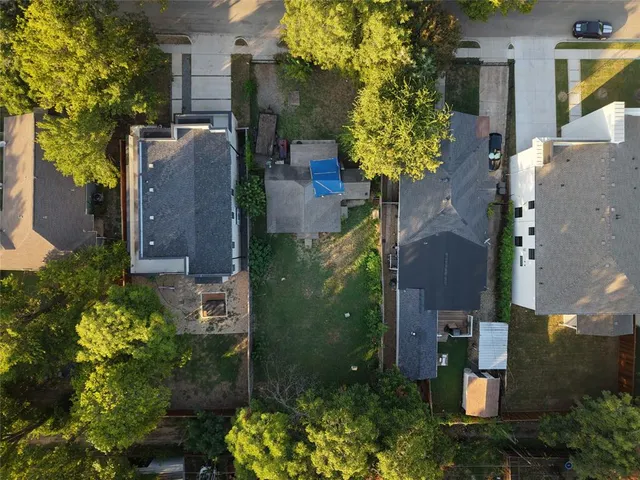 front view of a house with a yard and potted plants