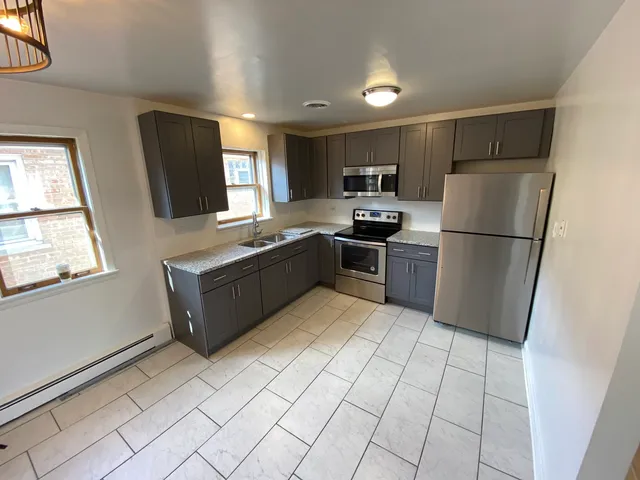 a kitchen with stainless steel appliances granite countertop a refrigerator sink and microwave