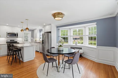a kitchen with a dining table chairs and refrigerator