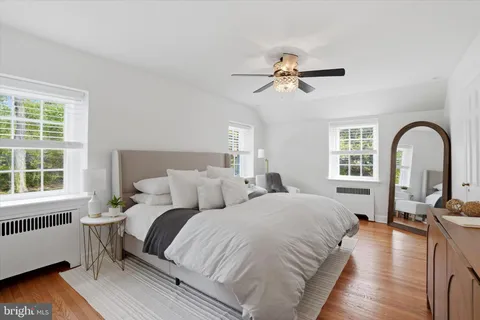 a bedroom with a bed wooden floor and window