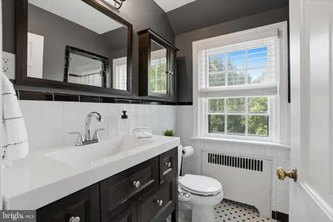 a bathroom with a sink vanity mirror and toilet