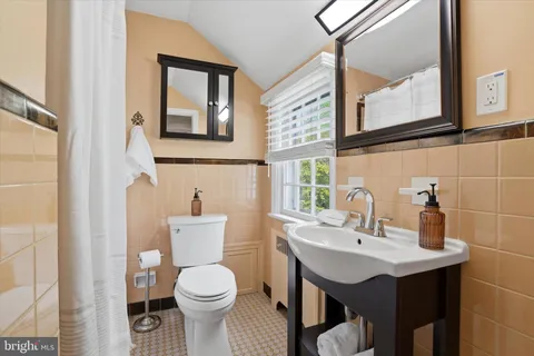 a bathroom with a toilet a sink and mirror