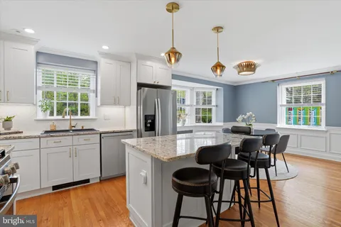 a kitchen with stainless steel appliances granite countertop table chairs and chandelier