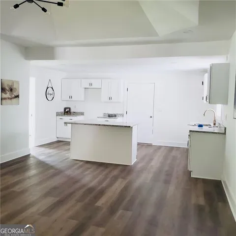 a view with a kitchen with a sink dishwasher stove and cabinets