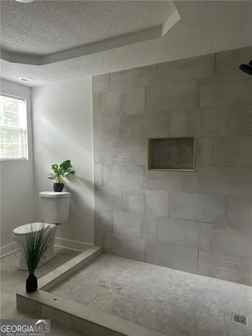 a bathroom with a granite countertop sink a toilet and a mirror