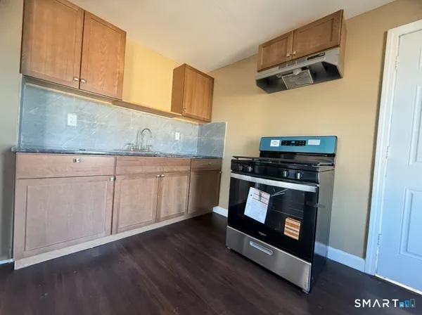 a kitchen with cabinets and wooden floor