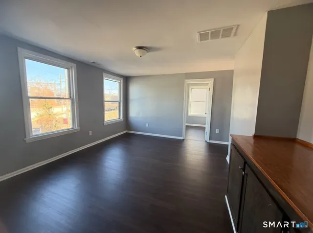 a view of room with window and wooden floor
