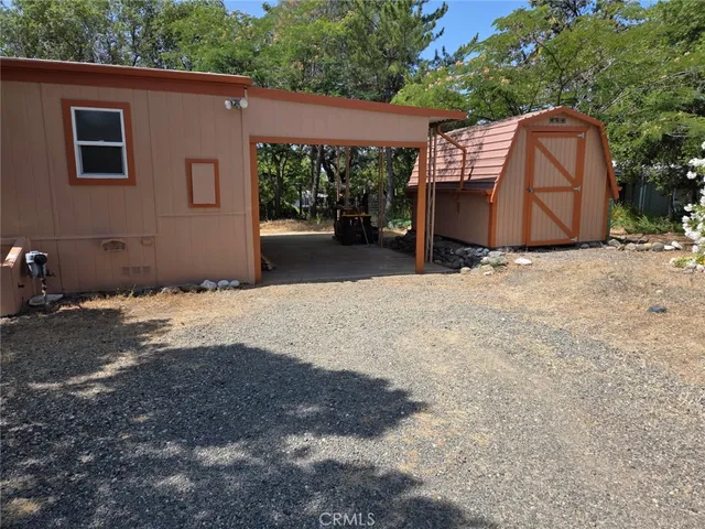 a backyard of a house with wooden fence and a bench