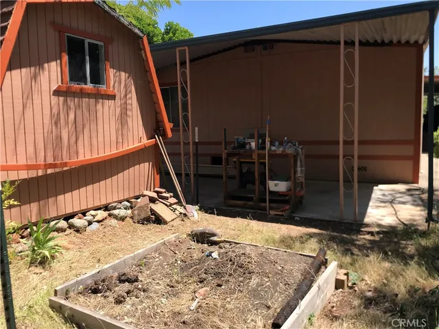 a backyard of a house with large trees and outdoor seating