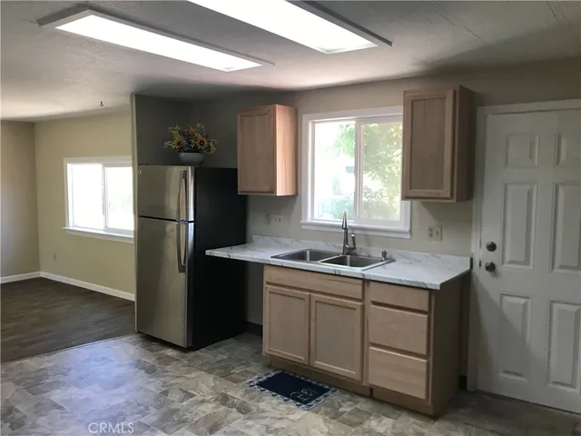 a kitchen with a sink refrigerator and window