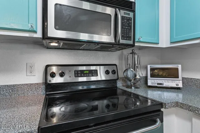 a bedroom with a bed a computer on desk and a window