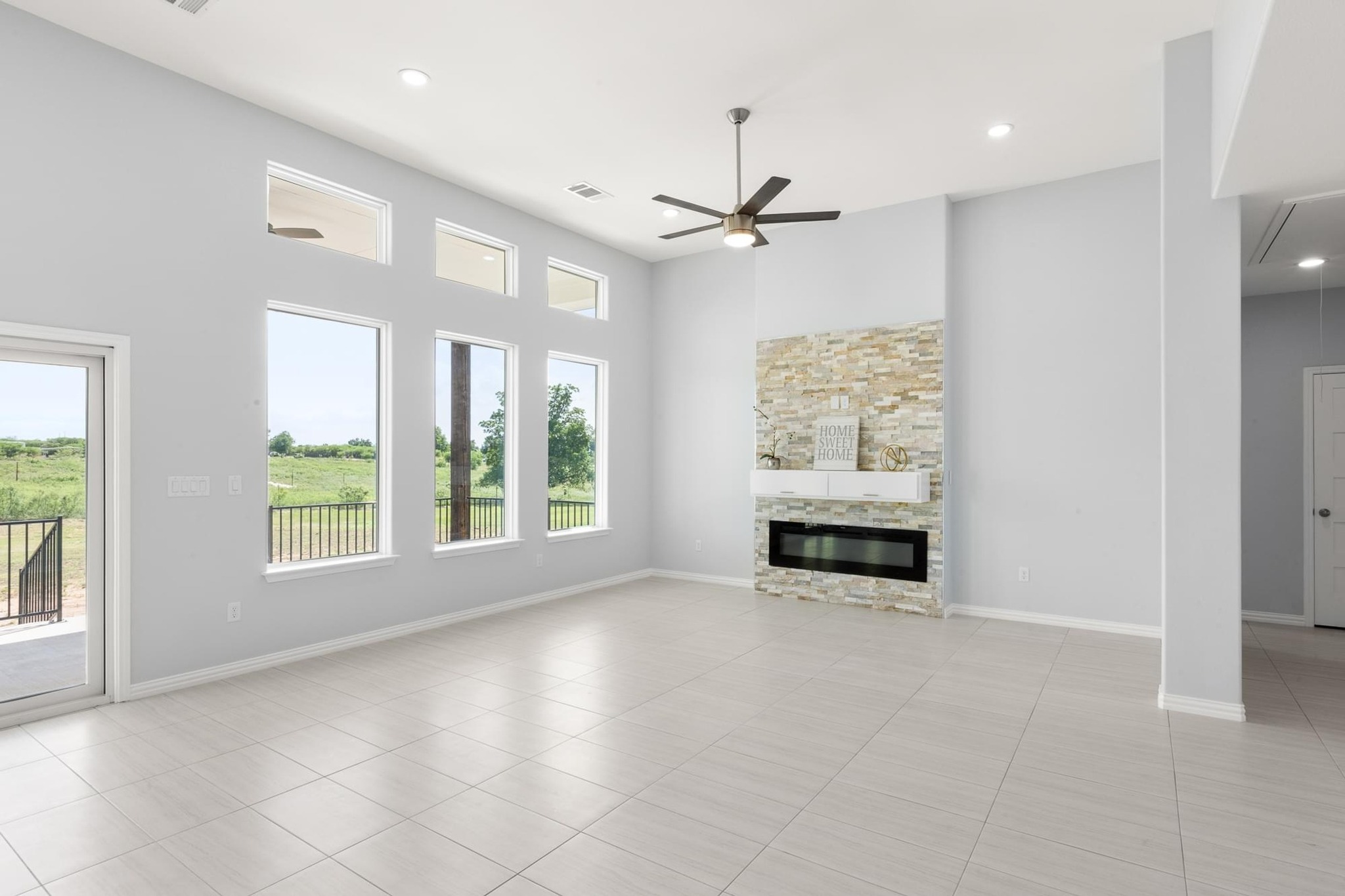 1136 County Road 484 Elgin, TX 78621 - Photo 8 of 37 Unfurnished living room with attic access, ceiling fan, recessed lighting, a fireplace, and a high ceiling