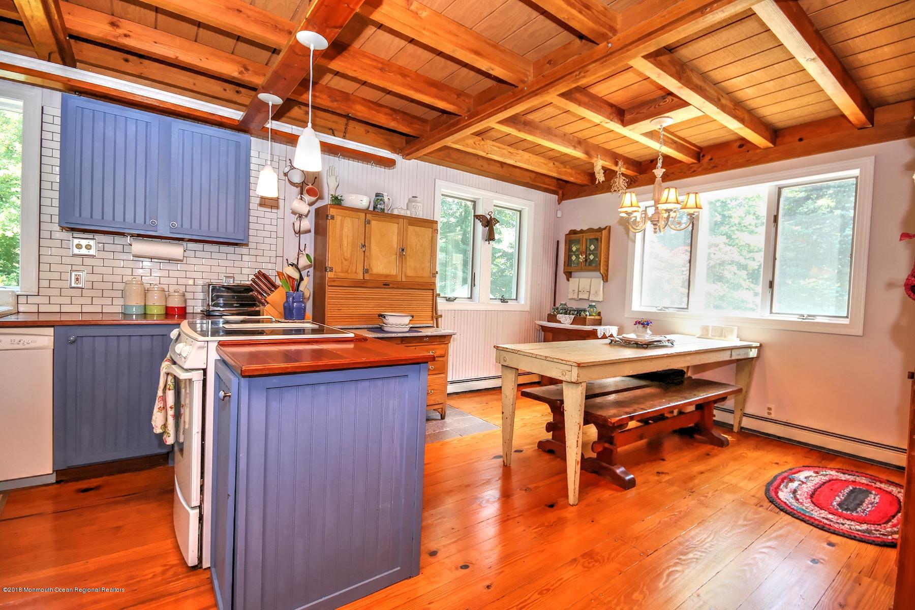 186 Merrick Road Farmingdale, NJ 07727 - Photo 8 of 35 a kitchen with wooden cabinets and wooden floors
