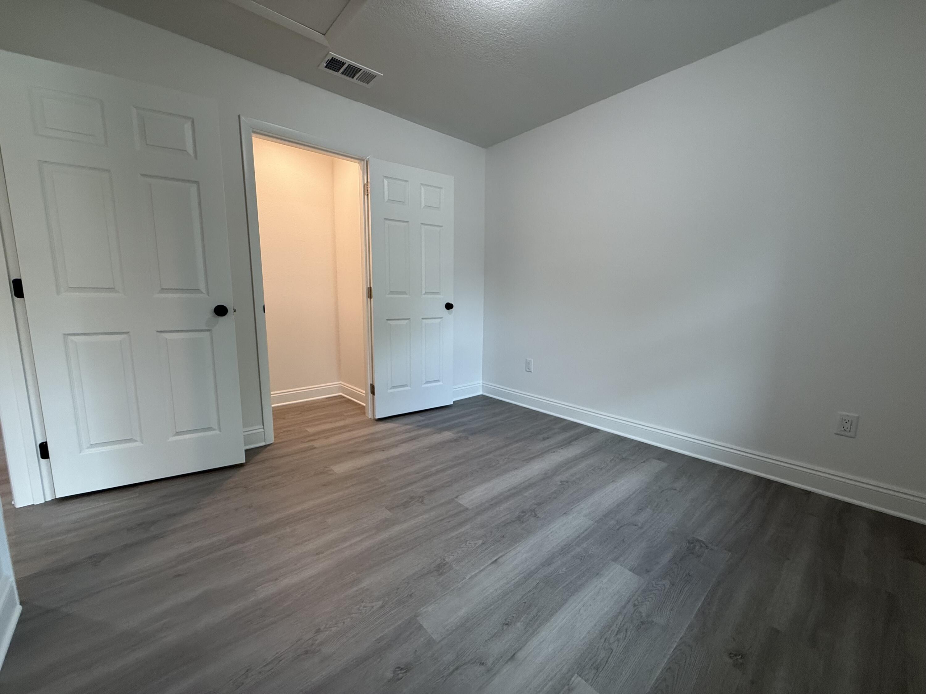 32 Constitution Avenue, Unit AB DeFuniak Springs, FL 32433 - Photo 11 of 22 a view of an empty room with wooden floor and a window
