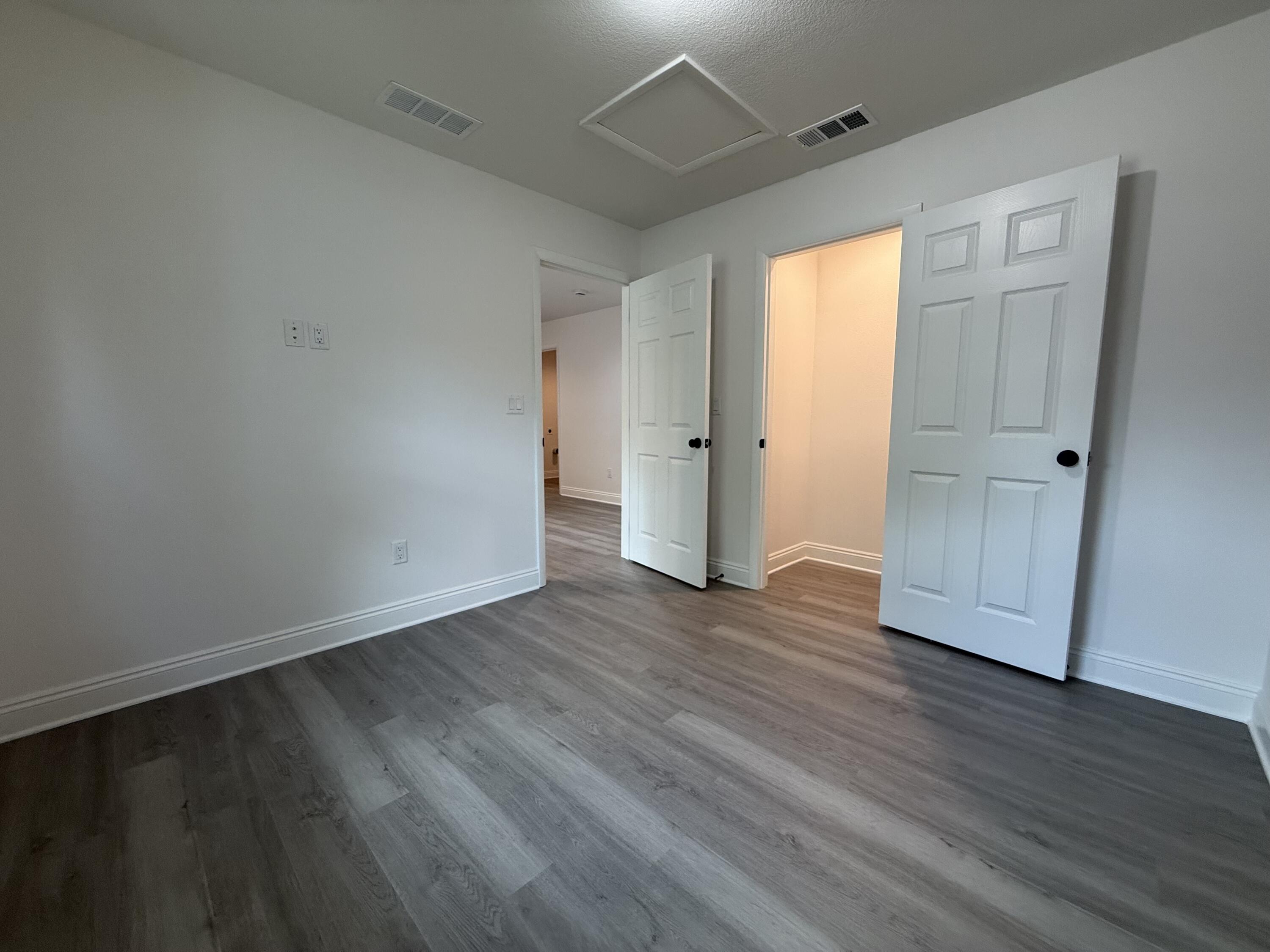 32 Constitution Avenue, Unit AB DeFuniak Springs, FL 32433 - Photo 12 of 22 a view of an empty room with wooden floor and a window