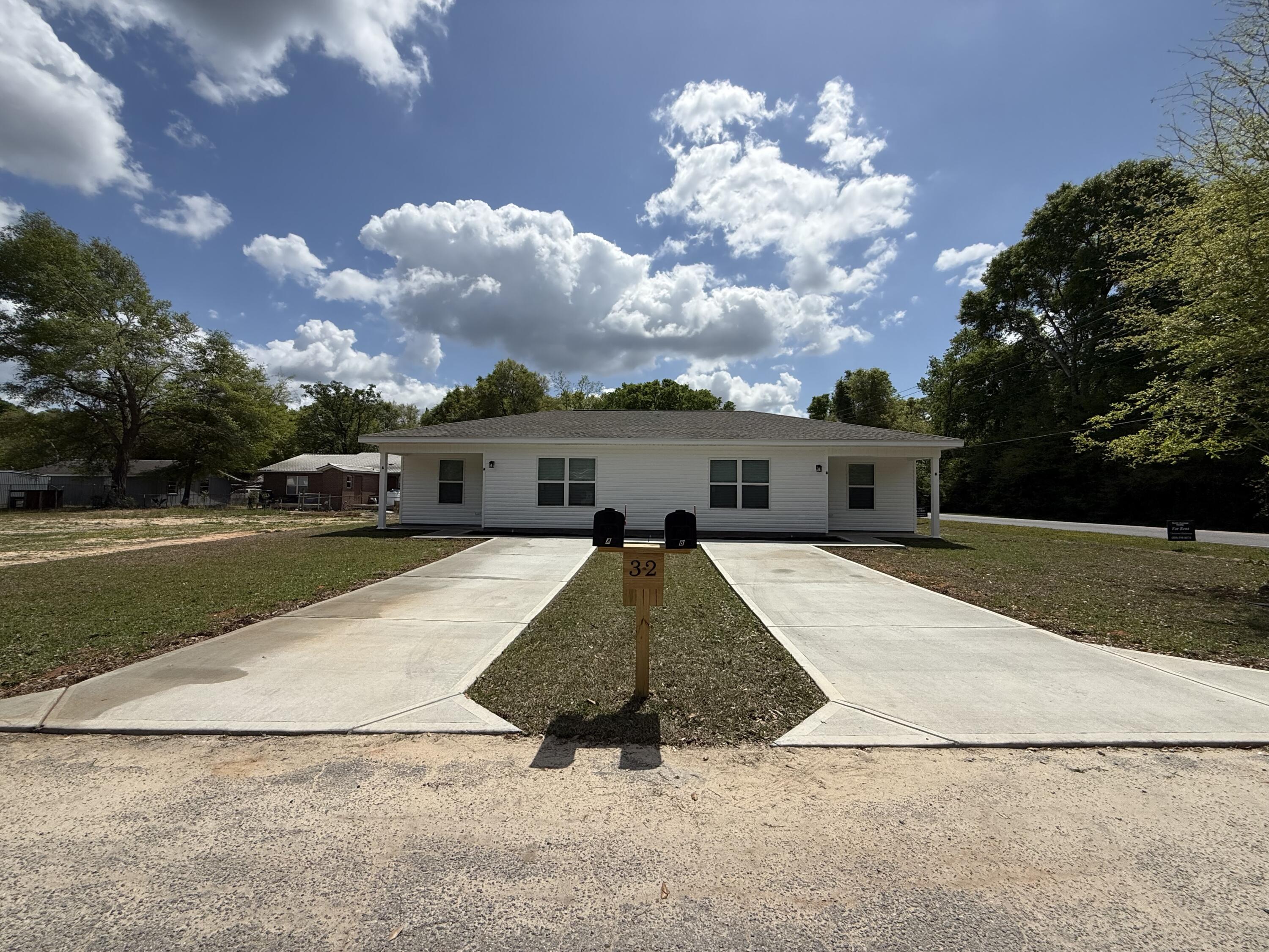 32 Constitution Avenue, Unit AB DeFuniak Springs, FL 32433 - Photo 22 of 22 a front view of a house with a yard
