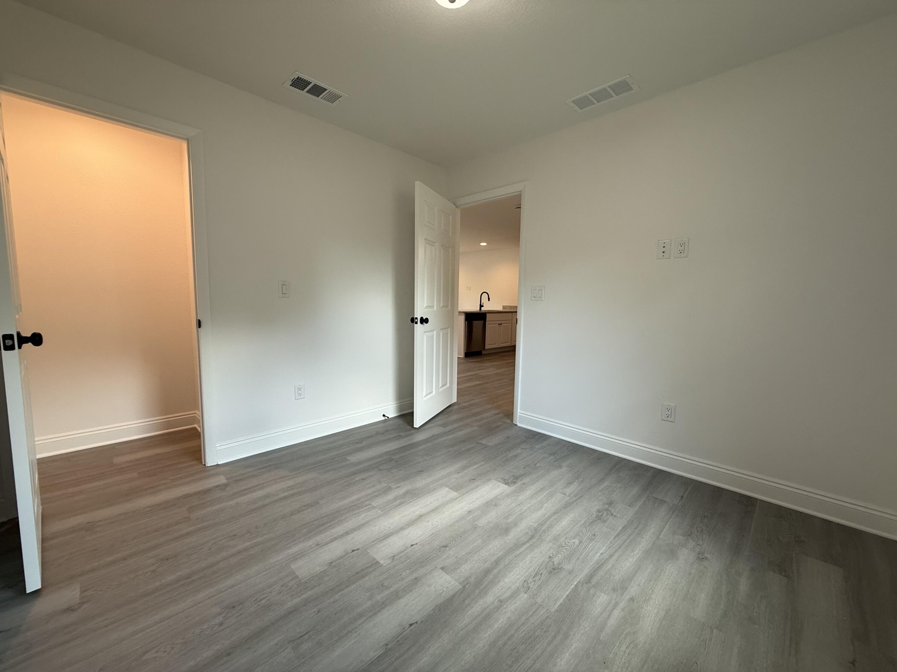 32 Constitution Avenue, Unit AB DeFuniak Springs, FL 32433 - Photo 9 of 22 an empty room with wooden floor and a window