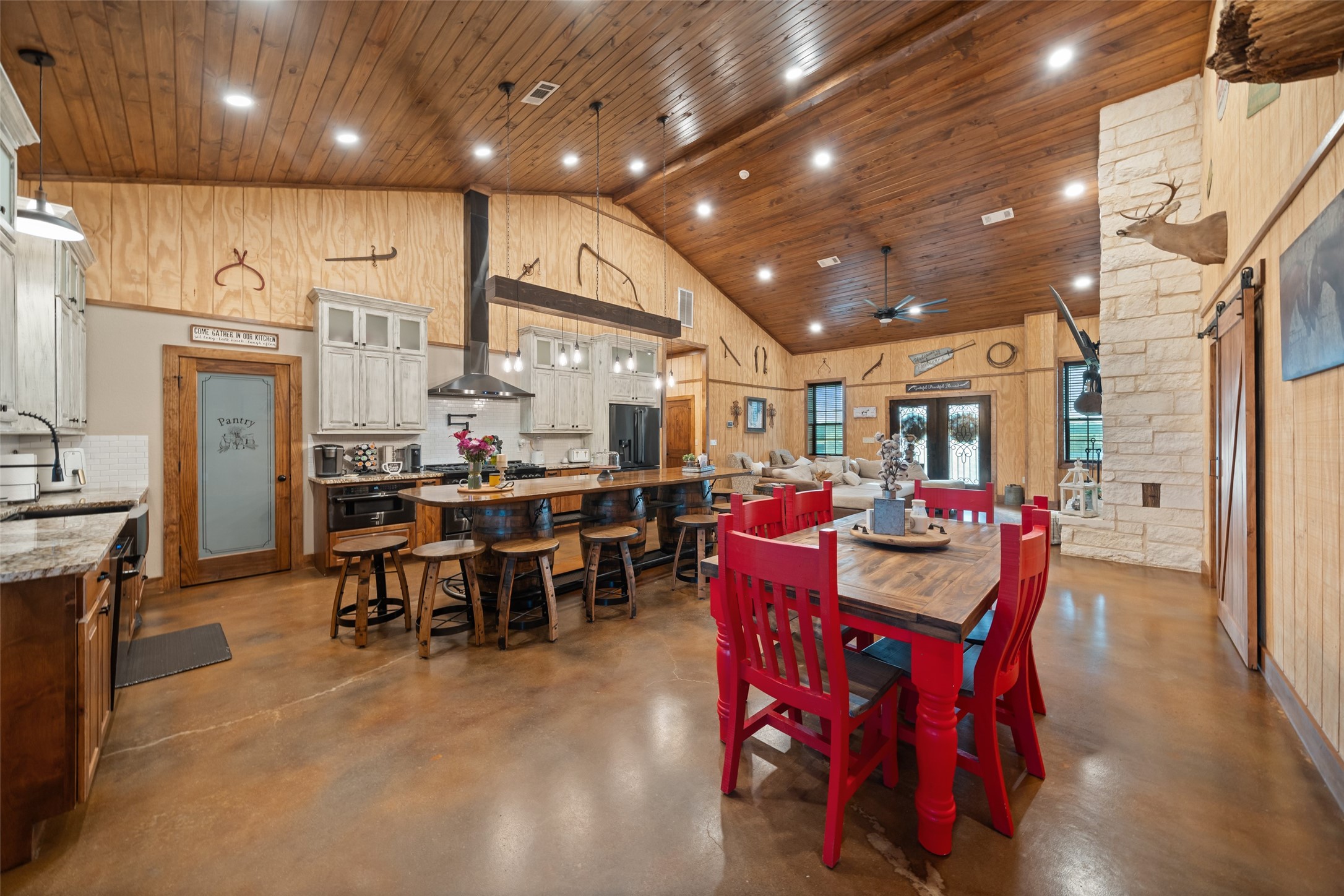 1402 Eagle Ferry Road Anahuac, TX 77514 - Photo 23 of 48 Vaulted wood ceilings with tongue-and-groove detail and energy-efficient LED lighting create a warm, inviting atmosphere from kitchen to living space. Optional chandelier can be installed above the dining room table as it is pre-wired and connected to a switch.