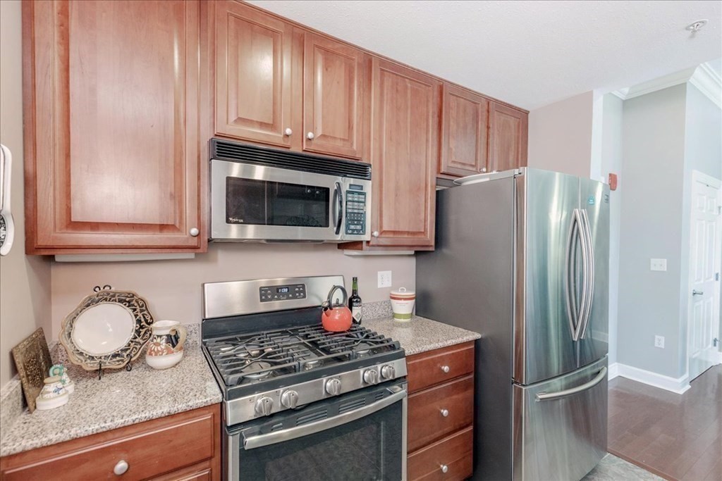 36 Village Road, Unit 706 Middleton, MA 01949 - Photo 11 of 42 a kitchen with stainless steel appliances granite countertop a refrigerator stove and sink