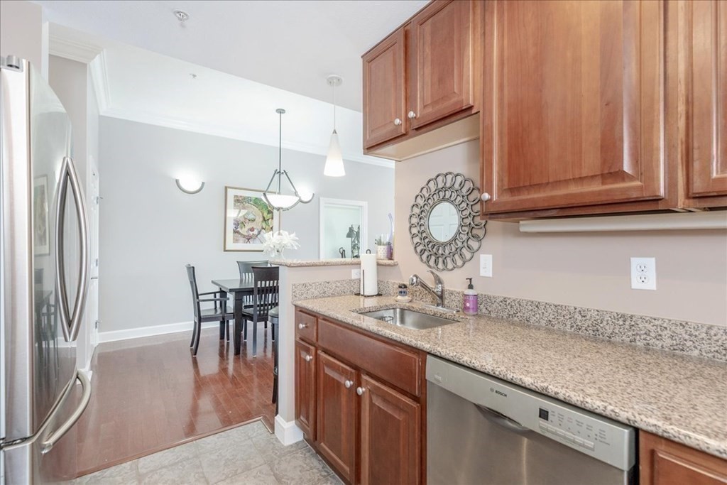 36 Village Road, Unit 706 Middleton, MA 01949 - Photo 12 of 42 a kitchen with stainless steel appliances granite countertop a sink and a refrigerator
