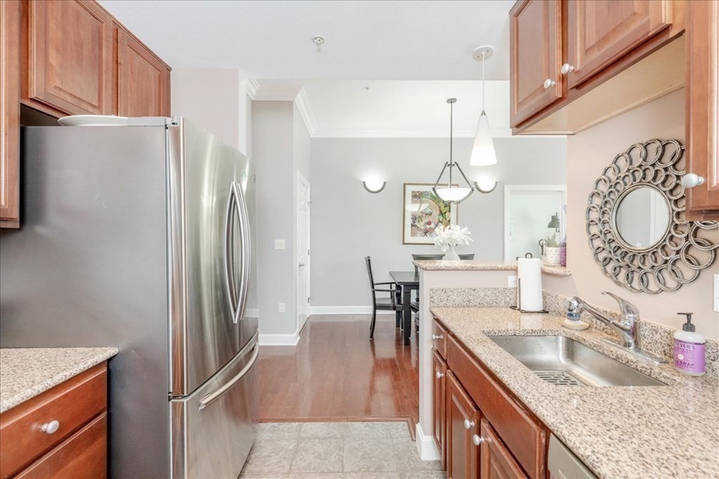 36 Village Road, Unit 706 Middleton, MA 01949 - Photo 13 of 42 a kitchen with granite countertop a refrigerator a stove and a sink