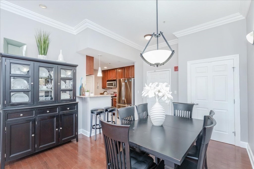 36 Village Road, Unit 706 Middleton, MA 01949 - Photo 14 of 42 a dining room filled chandelier and wooden floor