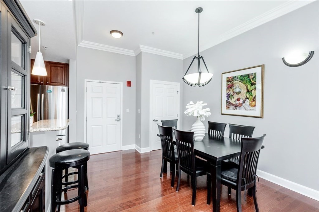 36 Village Road, Unit 706 Middleton, MA 01949 - Photo 7 of 42 a view of a dining room with furniture wooden floor and a chandelier