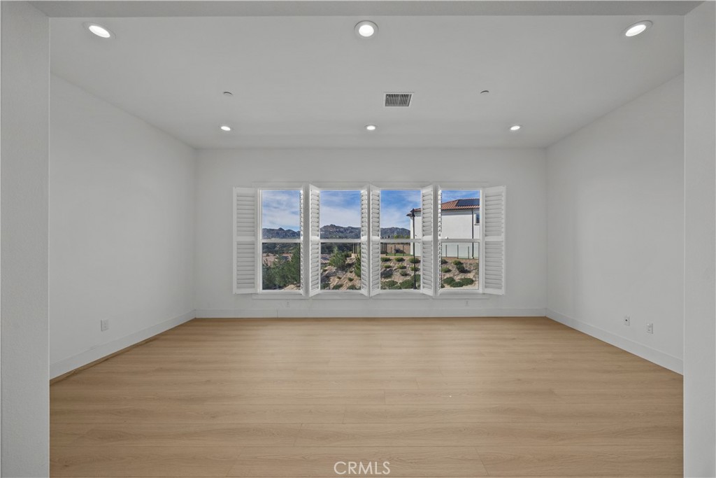 20638 Deer Grass Court Porter Ranch, CA 91326 - Photo 12 of 50 an empty room with wooden floor and windows