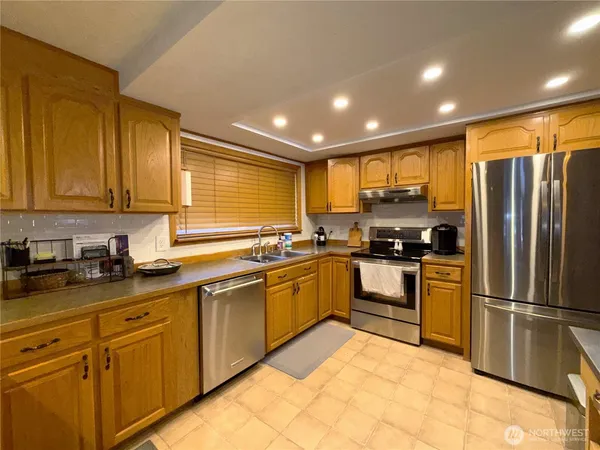 a kitchen with granite countertop stainless steel appliances a refrigerator sink and microwave