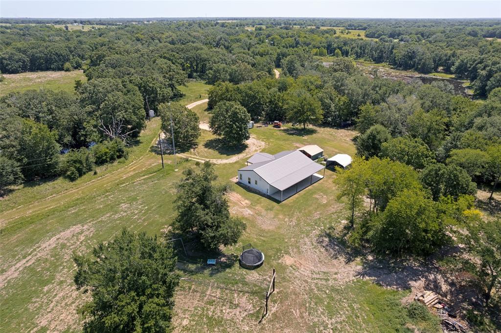 822 Private Road 7370 Point, TX 75472 - Photo 1 of 30 Ranch-style residence with a metal roof and an expansive covered porch, set amidst extensive natural landscaping featuring mature trees and open fields