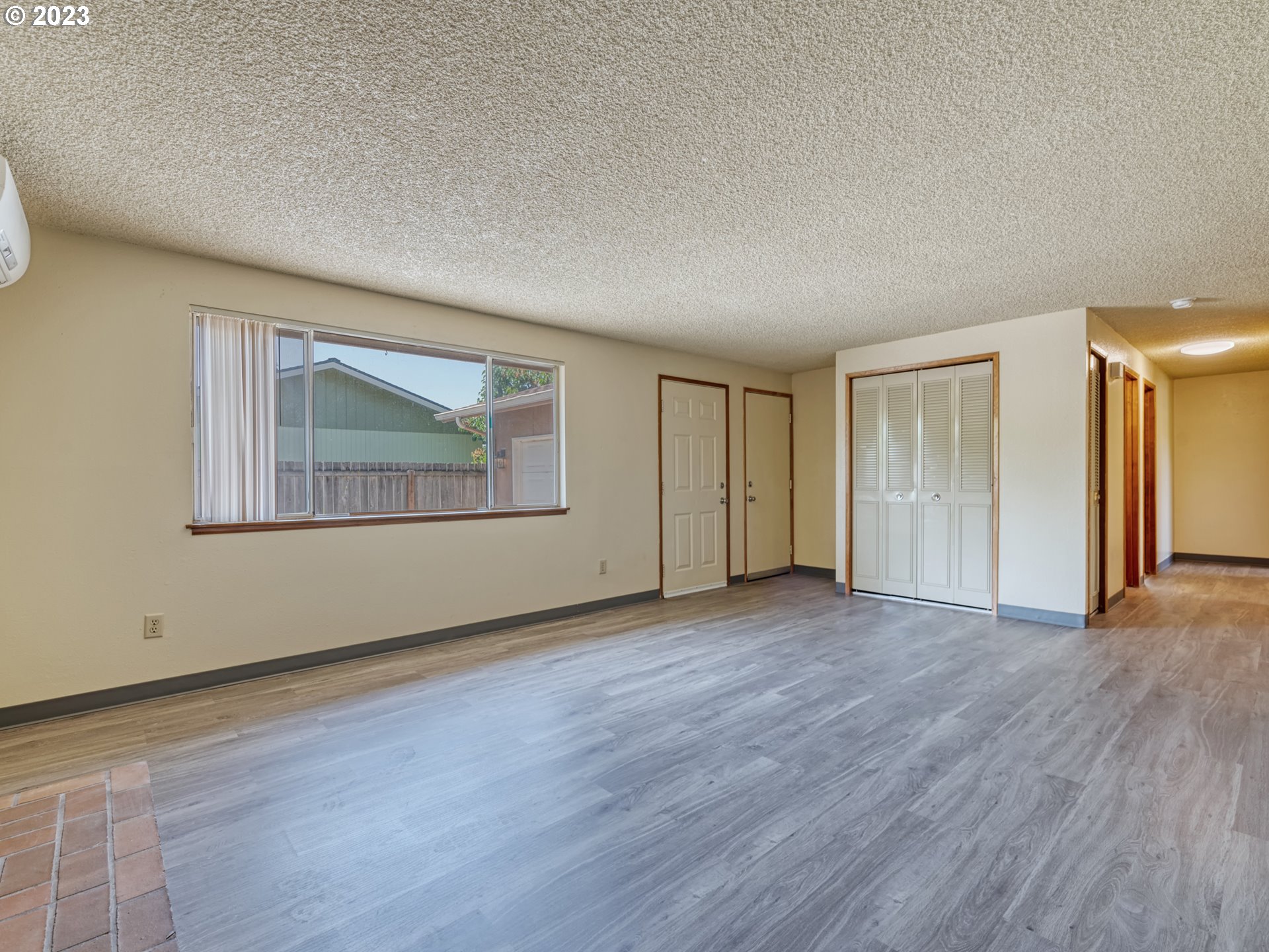 1249 6th Street Springfield, OR 97477 - Photo 6 of 24 a view of an empty room with wooden floor and a window
