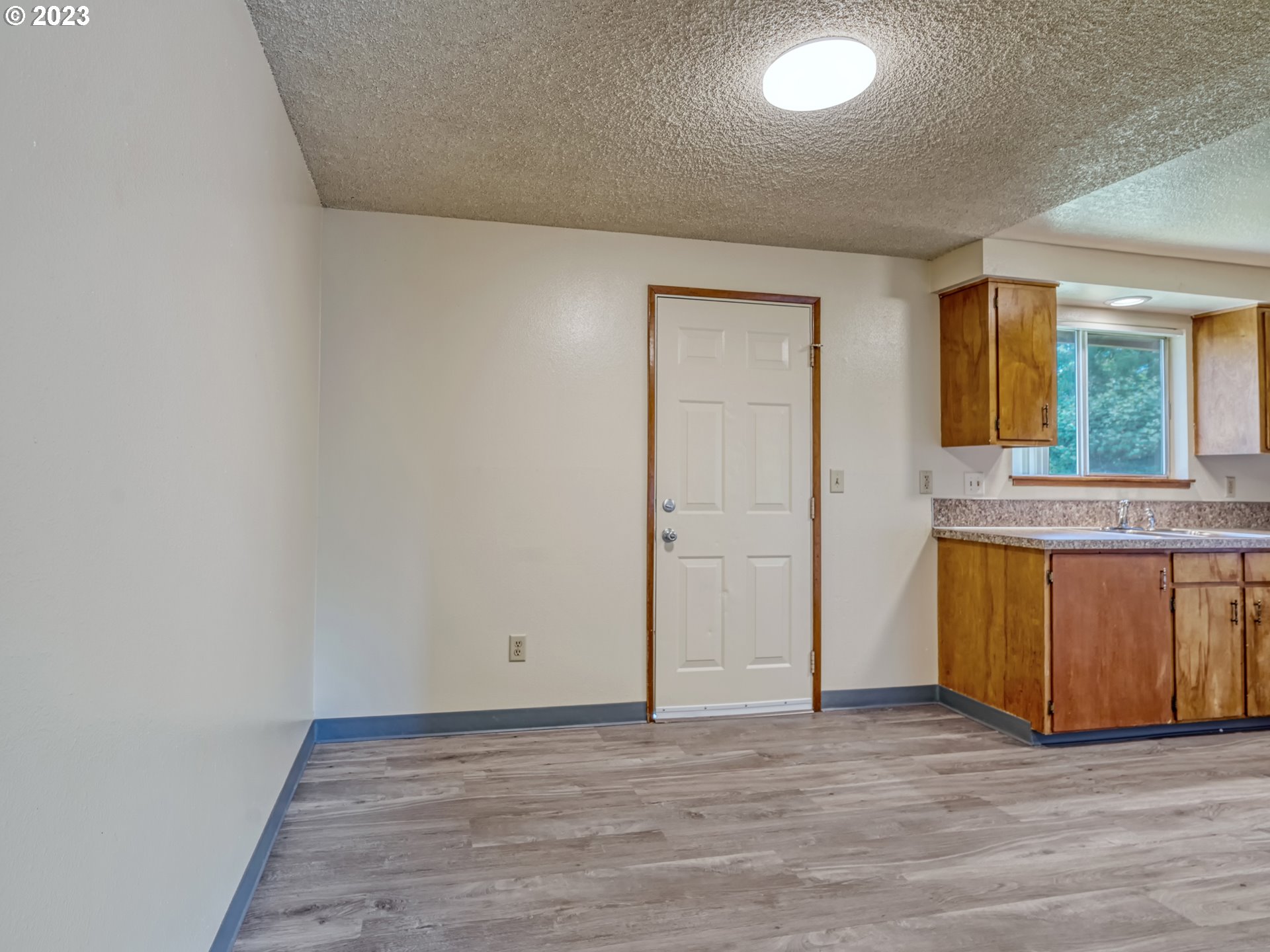 1249 6th Street Springfield, OR 97477 - Photo 7 of 24 an empty room with wooden floor and window