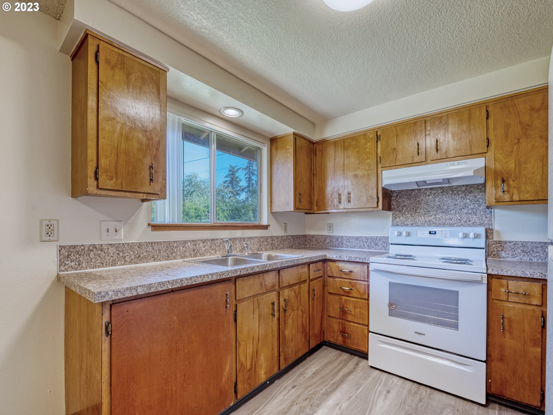 1249 6th Street Springfield, OR 97477 - Photo 10 of 24 a kitchen with stainless steel appliances granite countertop a sink stove and cabinets