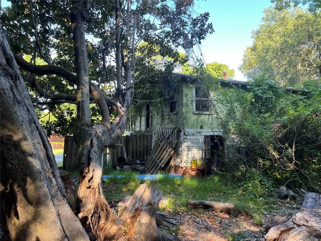 a view of a house with a yard and a tree