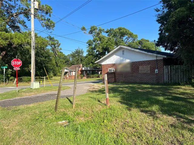a backyard of a house with table and chairs plants and large tree