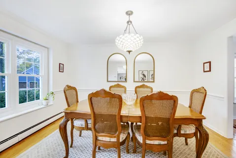 a view of a dining room with furniture a chandelier and wooden floor