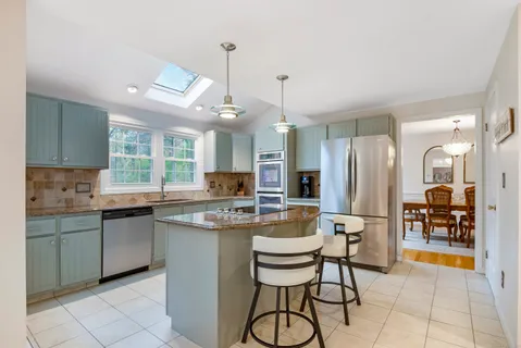 a kitchen with stainless steel appliances kitchen island granite countertop a sink and cabinets