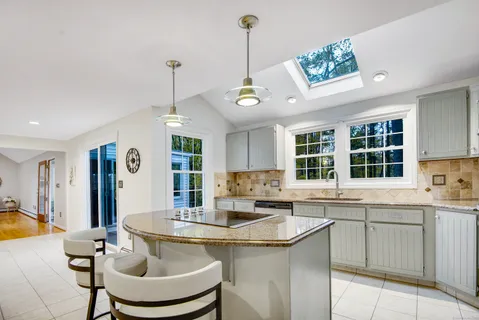 a kitchen with a sink stove and chairs