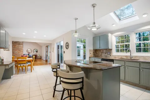 a kitchen with living room and chairs